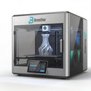A Brenthor 3D printer, utilizing Fused Deposition Modeling (FDM) technology, actively printing a complex, twisted object with white filament. Two spools of colored filament (blue and green) are visible in a side compartment, demonstrating its capability for additive manufacturing and rapid prototyping in engineering and design applications.