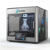 A Brenthor 3D printer, utilizing Fused Deposition Modeling (FDM) technology, actively printing a complex, twisted object with white filament. Two spools of colored filament (blue and green) are visible in a side compartment, demonstrating its capability for additive manufacturing and rapid prototyping in engineering and design applications.