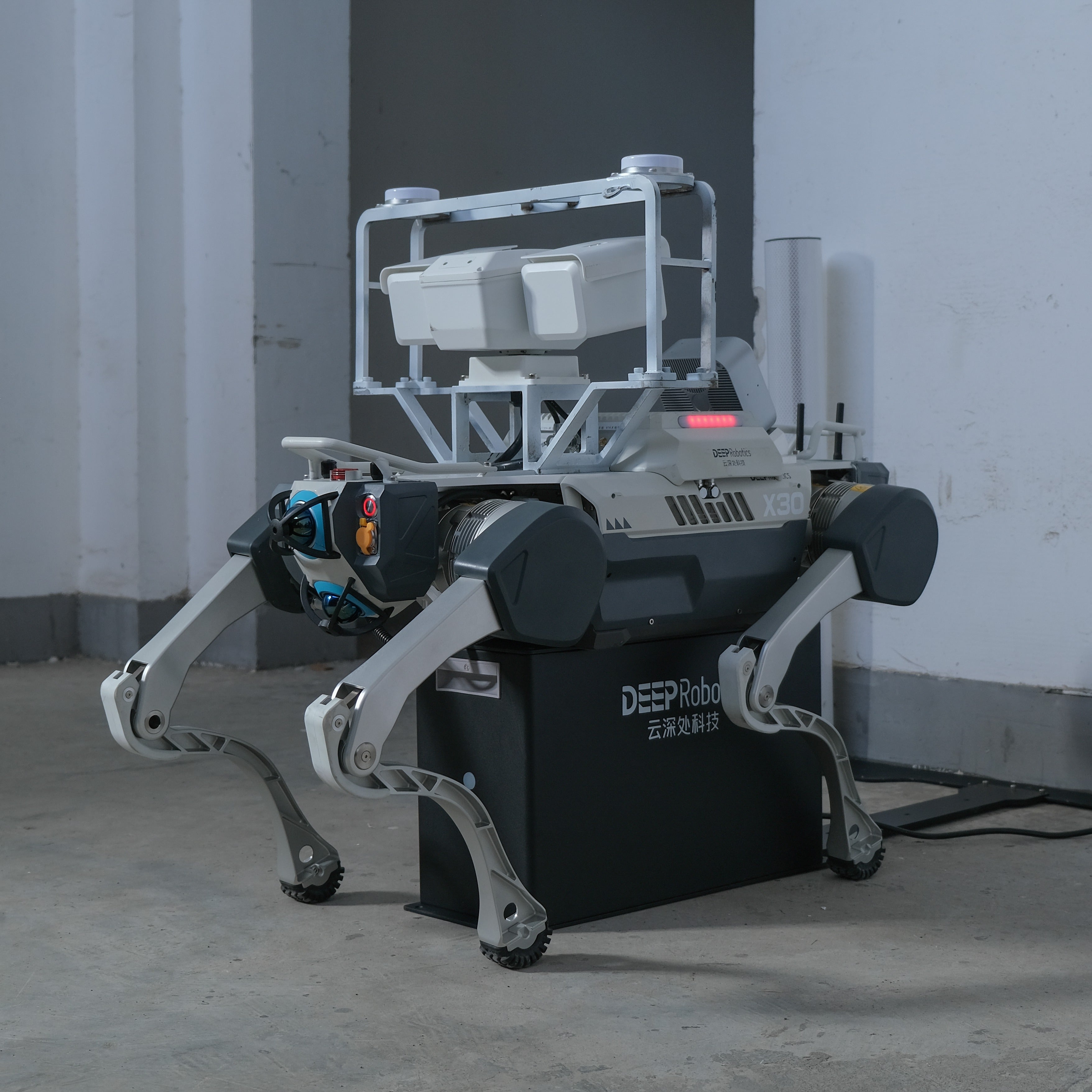 A DEEP Robotics X30 Pro quadruped robot is auto-charging on a charging dock. The robot is equipped with an HD camera and an acoustic camera, performs autonomous industrial inspection. This rugged robot is designed for navigating complex and hazardous environments, utilizing multi-sensor fusion with LiDAR and RTK for precise localization and obstacle avoidance, making it ideal for surveillance and data collection in various industrial applications.